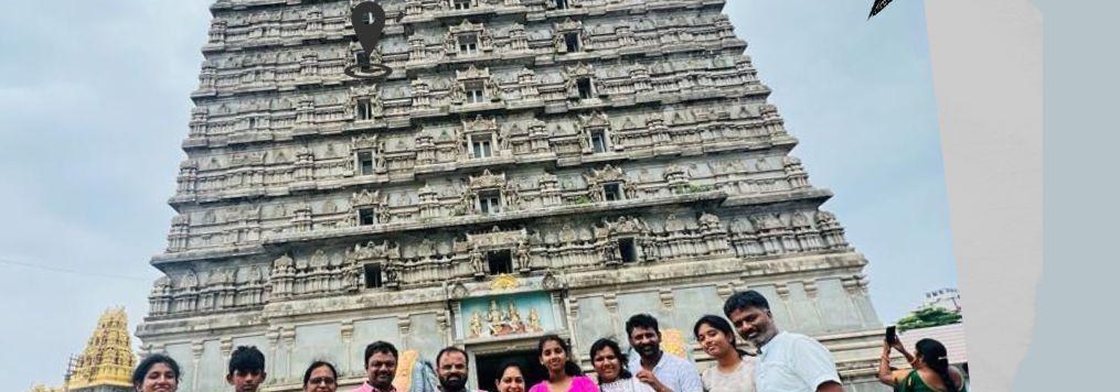 A group photographed at the foot of the temple tower in Murudeshwar